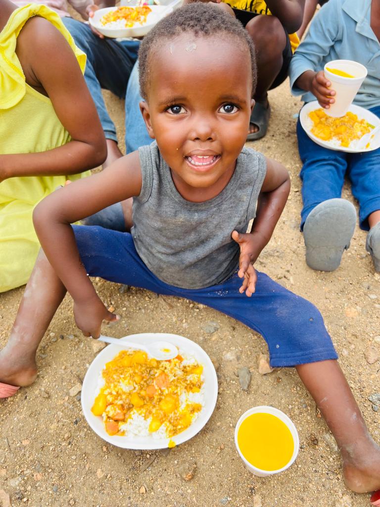 SPCDC reachout day — child enjoying a hot meal